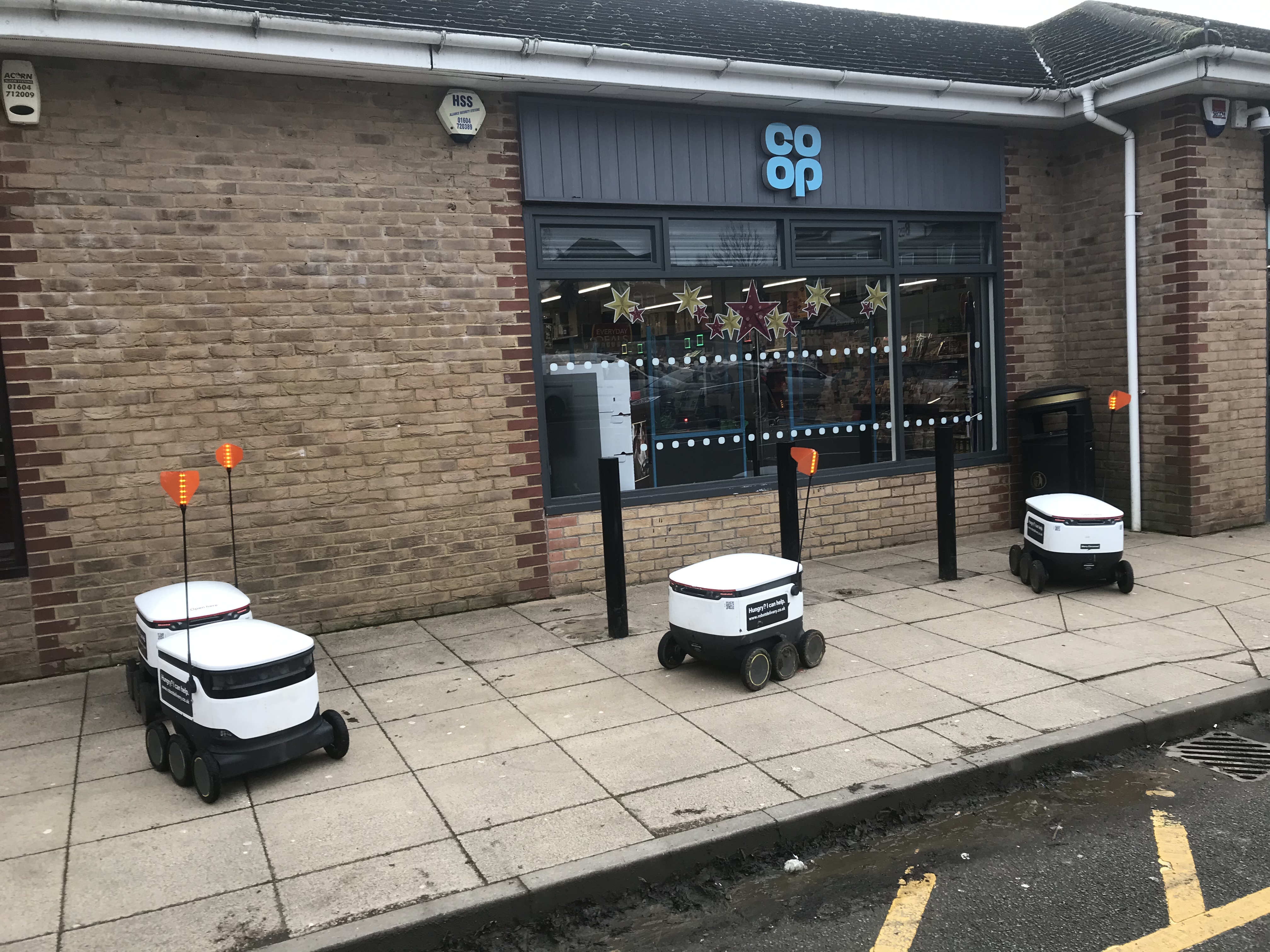 Quattro robot delle consegne Starship davanti al negozio Co-op di Wootton Fields, Northampton.